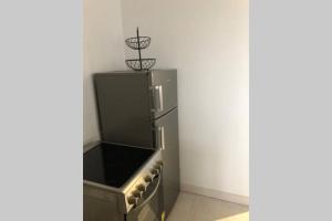 uma cozinha com um frigorífico de aço inoxidável num quarto em Studio sympathique proche de la gare et l’hopital em Montereau-faut-Yonne