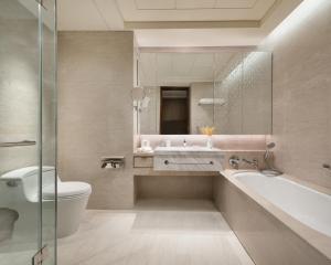 a bathroom with a tub and a toilet and a sink at Shangri-La Tangshan in Tangshan