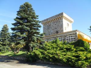 a large stone building with a tree in front of it at Hotel Temple Pradorrey in Astorga