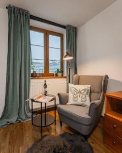 a living room with a chair and a table at Rodinný penzion Sobáčov in Sobačov