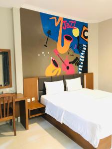 ein Schlafzimmer mit einem Bett und einem Wandgemälde in der Unterkunft Votel Viure Hotel Jogjakarta in Yogyakarta