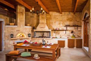 una cucina con tavolo in legno e parete in pietra di Elia Villas a Palaiokastro