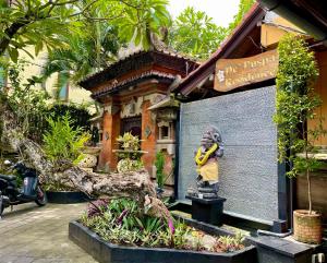 Una statua di un uomo che tiene una banana di fronte a un edificio. di De Puspa Residence Seminyak a Seminyak