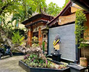 a statue of a man holding a banana in front of a building at De Puspa Residence Seminyak in Seminyak