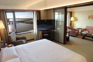 a hotel room with a bed and a flat screen tv at Shangri-La Harbin in Harbin