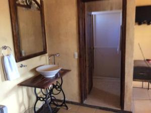 a bathroom with a sink and a mirror and a door at Hosteria Covadonga in Perote