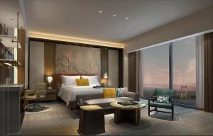 珠海市にあるInterContinental Zhuhai, an IHG Hotelのベッドとリビングルームが備わるホテルルームです。