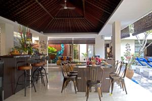 a kitchen and living room with a bar and chairs at Indi Villas - The Ambika in Seminyak