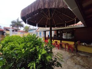 a patio with an umbrella and tables and chairs at Pousada Lagomar em Maricá in Maricá