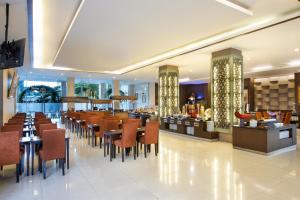 a restaurant with tables and chairs and a bar at Riss Hotel Malioboro in Yogyakarta