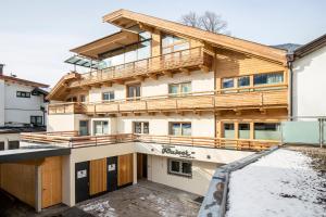 a house in the snow with a balcony at Apartment Rainer - mittendrin in Söll