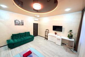 - un salon avec un canapé vert et une télévision dans l'établissement Apartment with 2 bedroom near Malevich and Opera House, à Lviv