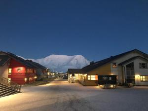 a street in a town with mountains in the background at Haugen Pensjonat Svalbard in Longyearbyen