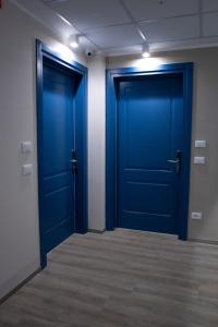 two blue doors in an empty room at Bob W Ticinese in Milan