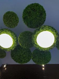 a wall of green plants with lights on it at Bob W Ticinese in Milan