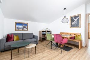 a living room with a couch and a table and chairs at Apartment Rainer - mittendrin in Söll