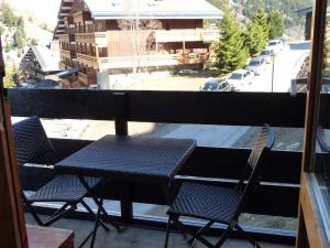 un balcón con 2 sillas y una mesa en el balcón en Comfortable flat close to the slopes and shops, en Les Allues