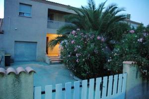アグドにあるVilla de 3 chambres avec piscine privee et jardin clos a Agde a 2 km de la plageの花の家の前の白い柵