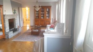 sala de estar con chimenea y silla en Villa de 6 chambres avec piscine privee jardin clos et wifi a Mur de Barrez, en Mur-de-Barrez