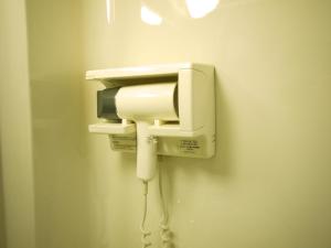 a phone on a wall with a cord plugged into it at Hotel Route-Inn Nahatomariko in Naha