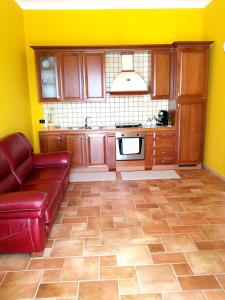 a kitchen with a red couch and yellow walls at One bedroom apartement with sea view and furnished garden at Montallegro 2 km away from the beach in Montallegro