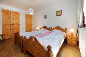 1 Schlafzimmer mit 2 Betten und Holzböden in der Unterkunft Appartement moderne aux Menuires - 90 m² - Vue montagne in Levassaix