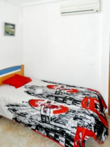 a bedroom with a bed with a black and red comforter at 2 bedrooms house with shared pool enclosed garden and wifi at Torrevieja 1 km away from the beach in Torrevieja