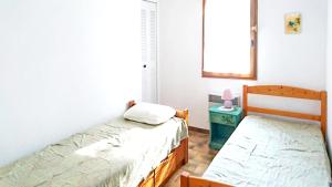 1 dormitorio con 2 camas individuales y ventana en Villa de 3 chambres avec piscine privee jardin clos et wifi a Saint Raphael a 6 km de la plage, en Saint-Raphaël