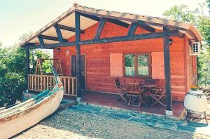 a small wooden cabin with a table and chairs at 2 bedrooms house with shared pool furnished garden and wifi at Canamero in Cañamero