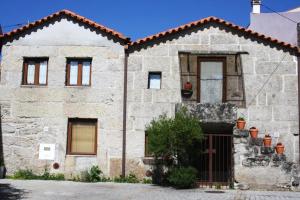 una casa de piedra con una puerta delante de ella en 4 bedrooms house with furnished terrace and wifi at Nogueira, en Moita