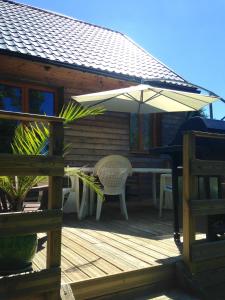 a wooden deck with a table and an umbrella at Maison de 2 chambres avec vue sur la ville jardin clos et wifi a Dainville in Dainville