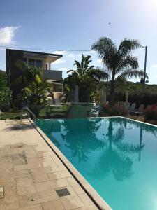 a large blue swimming pool in front of a house at Spacious Apartment in Pozzallo, 110m² with Pool and Sea View in Pozzallo
