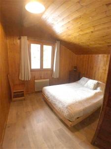 サン・シャフレにあるChalet de 4 chambres a Saint Chaffrey a 400 m des pistes avec terrasse amenagee et wifiの木造キャビン内のベッド1台が備わるベッドルーム1室を利用します。