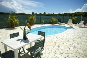 un patio con piscina, mesa y sillas en Villa élégante avec piscine privée à Saint-François, en Saint-François 23 fotos más