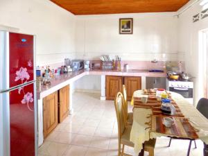 a kitchen with a table and a table and a refrigerator at 2 bedrooms appartement with sea view and furnished terrace at Majunga in Mahajanga