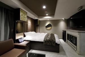 um quarto com uma cama, uma televisão e um sofá em ホテルバースデーきよす店 HOTEL Birthday kiyosu em Kiyosu
