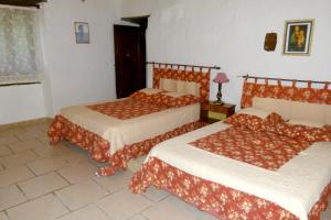 um quarto com 2 camas com lençóis vermelhos e brancos em Villa de 2 chambres avec piscine privee jardin clos et wifi a Ornezan em Ornézan