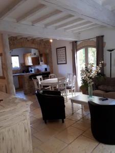 una cucina e un soggiorno con tavolo e sedie di Maison de 3 chambres avec piscine partagee jardin clos et wifi a Mons a Mons