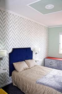 ein Schlafzimmer mit einem Bett und einer gestreiften Wand in der Unterkunft One bedroom appartement with sea view balcony and wifi at Funchal 2 km away from the beach in Funchal