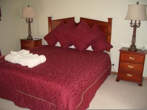 a bedroom with a red bed with two towels on it at Carolynnes Cottages in Naracoorte