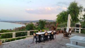 a table and chairs on a patio with a view of the water at 2 bedrooms house with sea view and furnished garden at Vasto 4 km away from the beach in Vasto