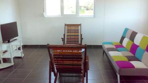 a living room with two chairs and a couch at Maison charmante à Macouria avec jardin et climatisation. in Guenouillet