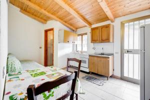 una cucina con tavolo e una cucina con frigorifero di One bedroom apartement at Pisciotta 200 m away from the beach with furnished terrace a Pisciotta