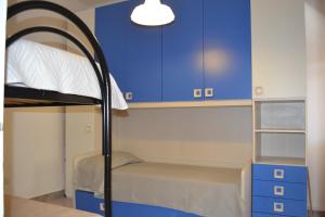 トッレ・ラピッロにあるVilletta Romeoの二段ベッドと青いキャビネットが備わる小さな客室です。