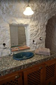 kamienna łazienka z umywalką i lustrem w obiekcie Cozy house in Gorafe + pool w mieście Gorafe