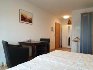 Schlafzimmer mit einem Bett, einem Schreibtisch und einem Tisch in der Unterkunft Appartementanlage Yachthafenresidenz in Kühlungsborn
