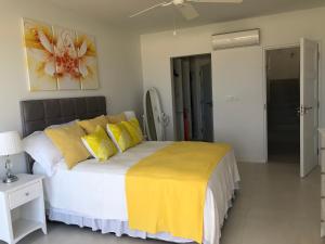 a bedroom with a large bed with yellow pillows at Westmoreland Hills - Mount Standfast - St James - Full Gym Membership in Saint James +34 photos