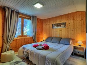 a bedroom with a large bed with wooden walls at Appartement cosy aux Carroz, 40 m², vue sur la montagne in Les Carroz d'Araches
