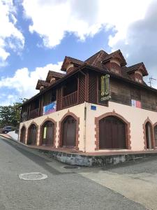 a building with brown doors on the side of a street at Appartement lumineux aux Trois-Îlets in Les Trois-Îlets
