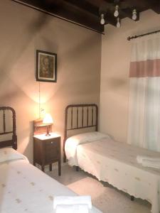 ein Schlafzimmer mit 2 Betten und einem Tisch mit einer Lampe in der Unterkunft 3 bedrooms villa with private pool and furnished terrace at El Saucejo in Saucejo